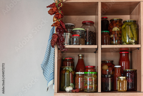 Homemade vegetables in jars on wooden shelves in the home pantry. Pickled food, as stocks from the autumn harvest, will be useful for self-isolation. Healthy healthy food from the garden.
