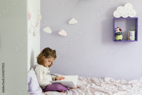 Girl child sit bed read book