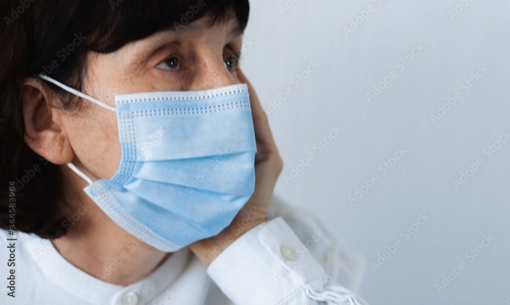 Coronavirus quarantine and Air pollution pm2.5 concept. Face of old sick woman wearing blue respirator mask for protect. Wuhan, China epidemic virus symptoms background.