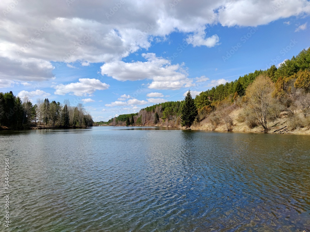 beautiful sky with clouds over the pond on a Sunny day overlooking the wooded shore beautiful sky with clouds over the pond on a Sunny day overlooking the wooded shore
