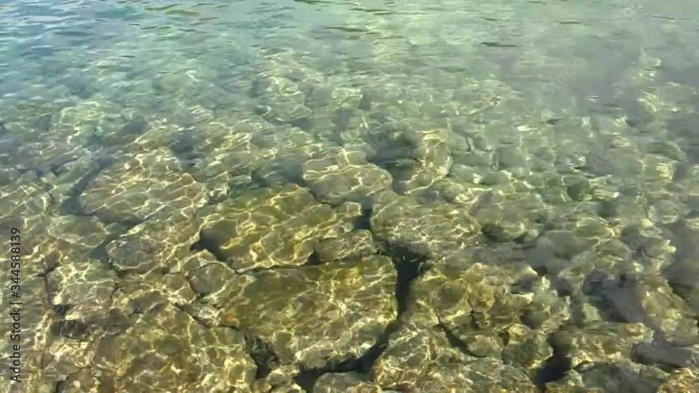 Sunbeams playing on the stones through the clear transparent water, slow motion Sunbeams playing on the stones through the clear transparent water, slow motion