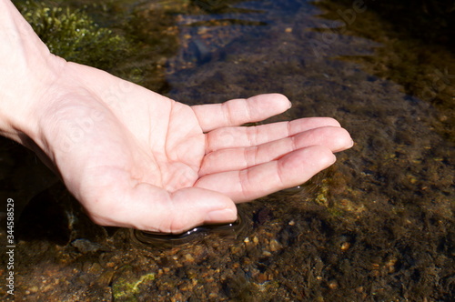 Hands touching the water of the river © travelers.high