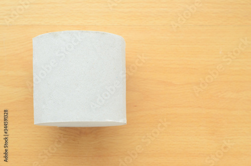 Top view, roll of toilet paper on wooden background.Space for text.