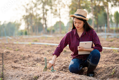 Asian female farmers are analyzing soil conditions and saving data on tablets.