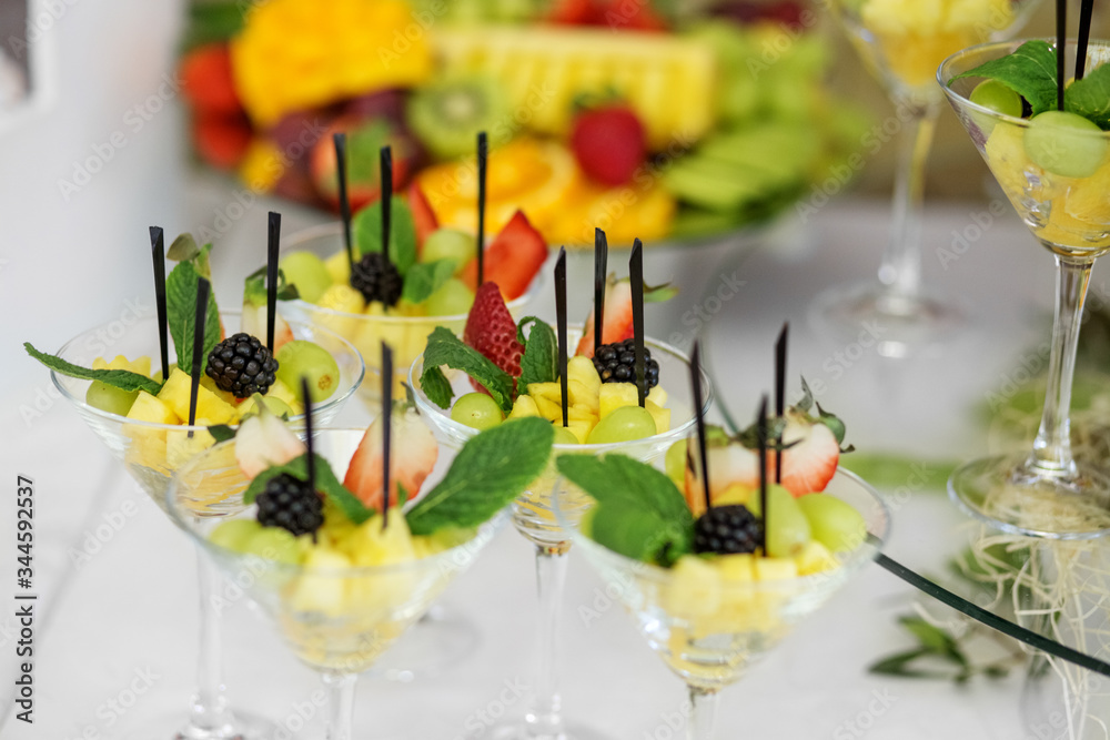 Fruit mix with pineapple, strawberries and blackberries and mint on the festive table. The concept of food, catering, restaurant and celebration. Fruit mix with pineapple, strawberries and blackberries and mint on the festive table. The concept of food, catering, restaurant and celebration.