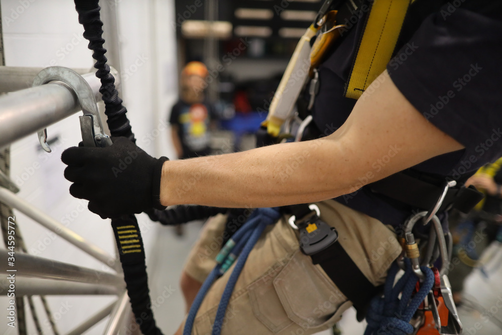 Trained competent rope access person working at heights wearing a fall