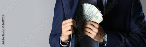 Fotografija Man putting bribe into pocket on grey background, closeup