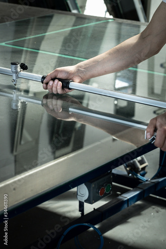 A worker cuts glass in a glass workshop 