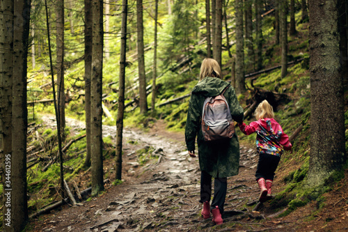 Mom and daughter are walking in the forest