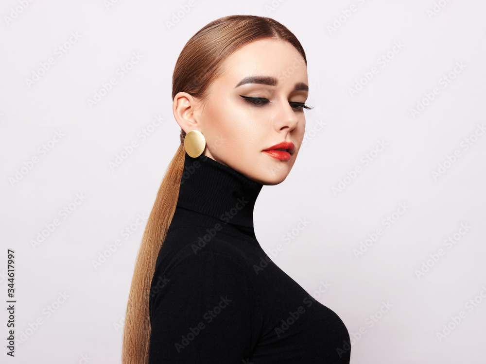 Art portrait of a beautiful, elegant woman in a black turtleneck and gold jewelry Art portrait of a beautiful, elegant woman in a black turtleneck and gold jewelry