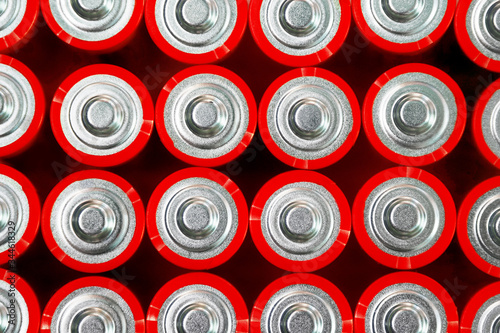 Red batteries top view, alkaline battery AA size format, macro. Energy abstract background