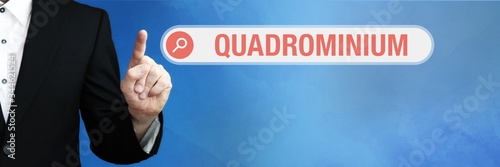 Quadrominium. Lawyer in suit points with his finger to a search box. The term Quadrominium is in focus. Concept for law, justice, jurisprudence photo