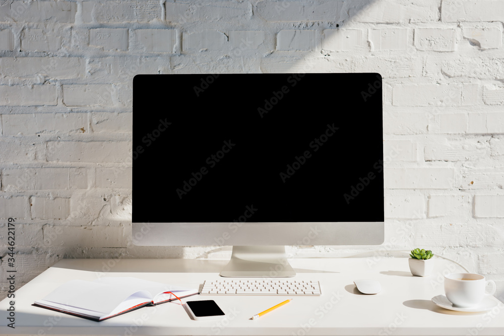 Fototapeta premium home office with notepad, cup of coffee, computer and smartphone with blank screens
