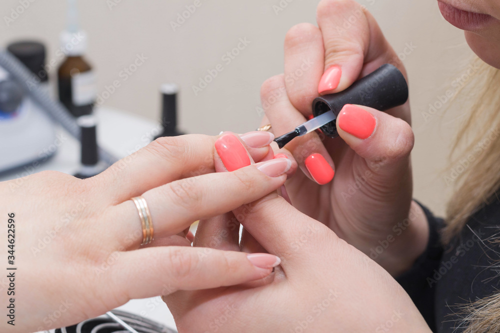 Manicuring nails - application of base coat. Selective focus, high key Manicuring nails - application of base coat. Selective focus, high key