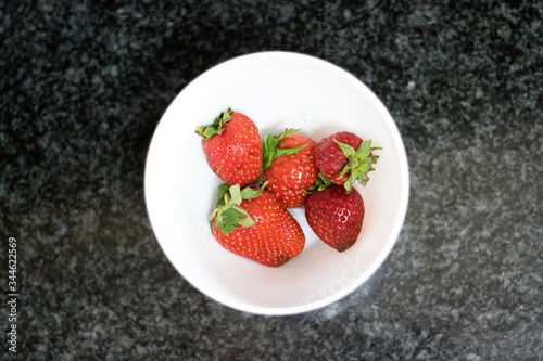 Top view of strawberries over dark marble