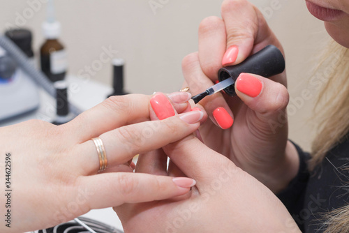 Manicuring nails - application of base coat. Selective focus  high key