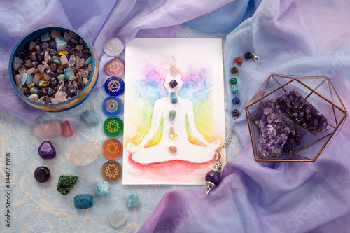 Natural crystals and pendulum on pastel silk background. Reiki background with card. photo