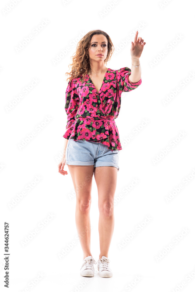 Confident young sexy casual woman in summer clothes pushing or clicking invisible button with finger. Full body length isolated on white background. Confident young sexy casual woman in summer clothes pushing or clicking invisible button with finger. Full body length isolated on white background.