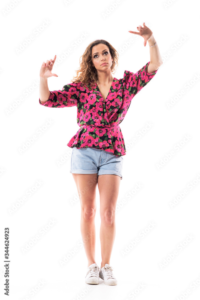 Young pretty casual woman interacting with invisible touch screen zooming or resizing gesture. Full body length isolated on white background. Young pretty casual woman interacting with invisible touch screen zooming or resizing gesture. Full body length isolated on white background.