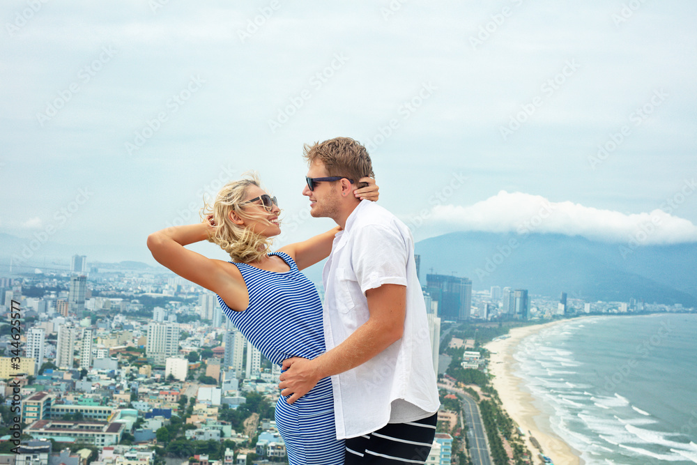 Couple a man and a woman happy, beautiful together against the background of the sea and the city on a summer day