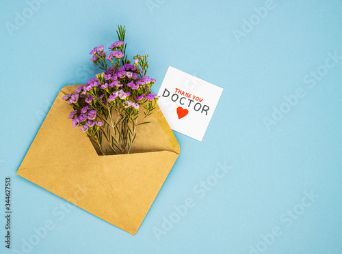 a bouquet of spring wildflowers in an envelope and the inscription thank you to the doctor