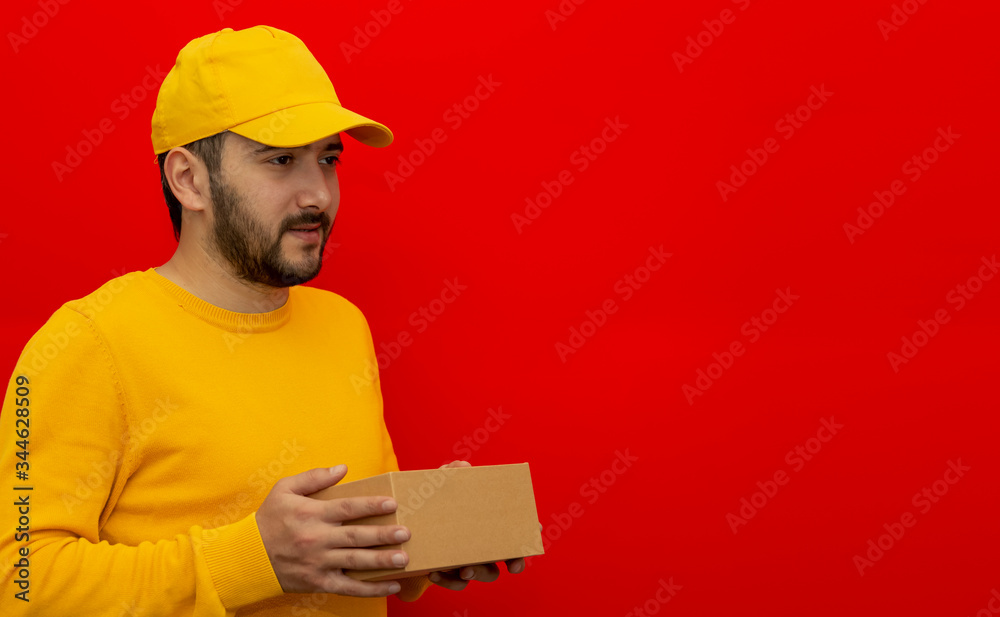 Courier. The guy is wearing a yellow shirt, shirt and cap. Online delivery. Place for logo and text. Layout. Mockup Courier. The guy is wearing a yellow shirt, shirt and cap. Online delivery. Place for logo and text. Layout. Mockup