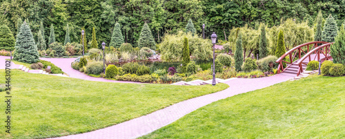 Panorama of the spring park in Mezhigorye near Kiev, Ukraine. Unique landscaping, a beautiful lake and a magnificent decorative garden against the backdrop of deciduous forest.
 photo