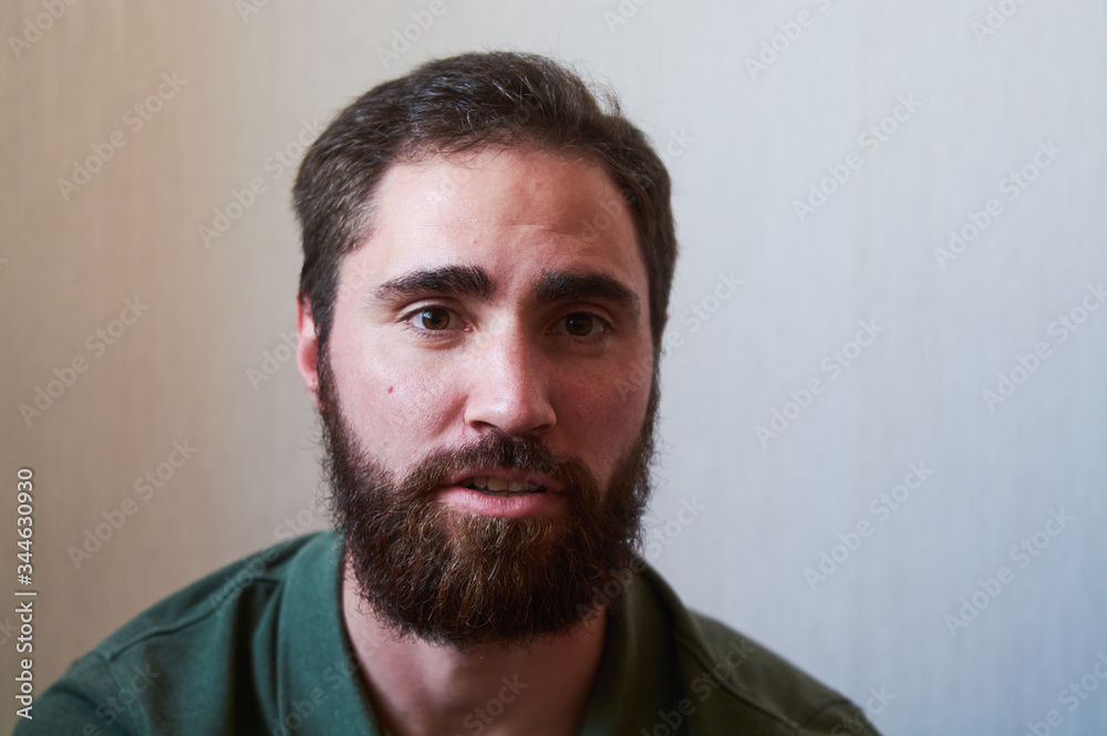 Portrait of young guy with dark beard with various emotions on his face in green shirt. Portrait of young guy with dark beard with various emotions on his face in green shirt.