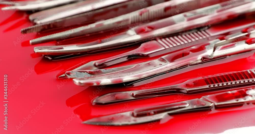Dolly in close up of surgical instrument tools with blood, scalpel forceps tweezers, scissors for surgeon in surgery Dolly in close up of surgical instrument tools with blood, scalpel forceps tweezers, scissors for surgeon in surgery