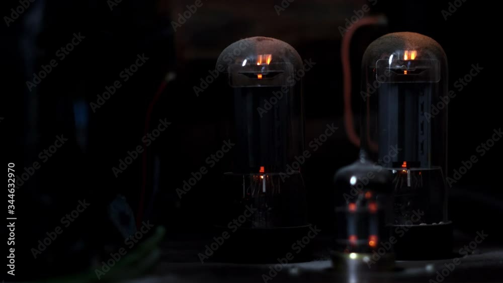 Retro vacuum tube amplifier in dark. Oldfashioned electronic device
