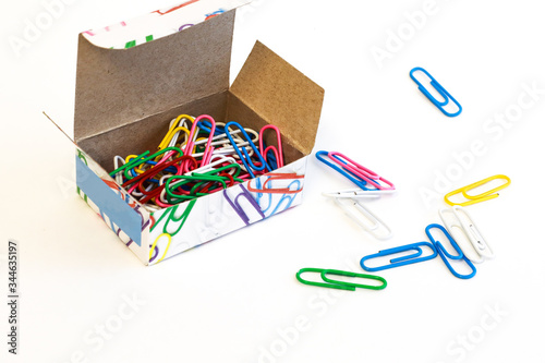 A bunch of colored clerical staples in a croarbka on a white background. Office accessories. Binding of documents and paper with the help of staples.