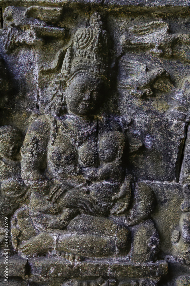 Sculped ancient women with big breasts and baby in her arm. Main pagoda of Prambanan Hindu Temple near Yogyakarta, Java island, Indonesia