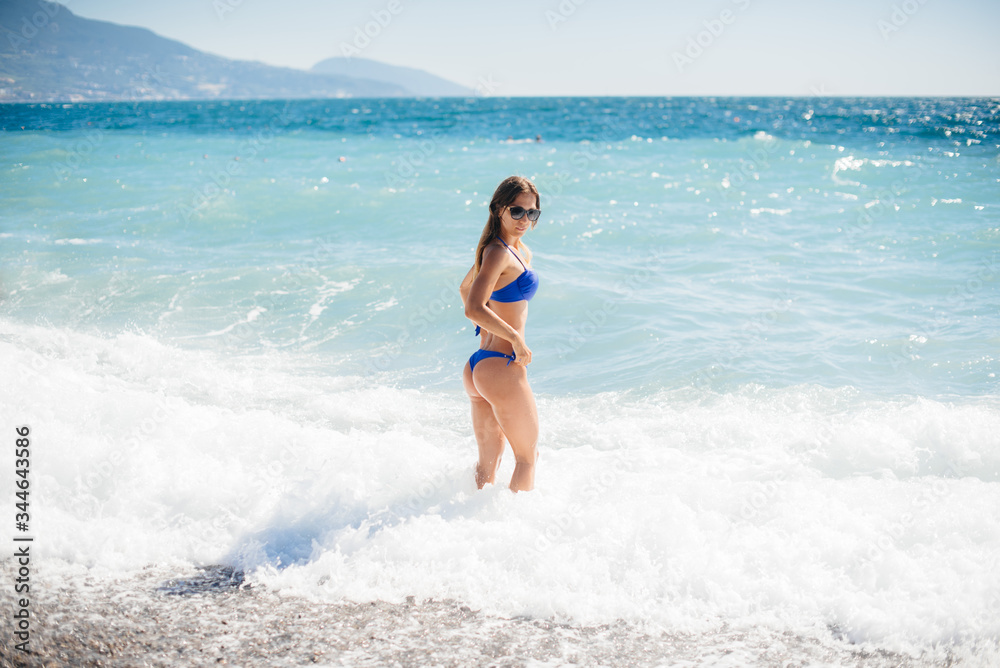 A young sexy girl is resting on the ocean on a Sunny day. Recreation, tourism