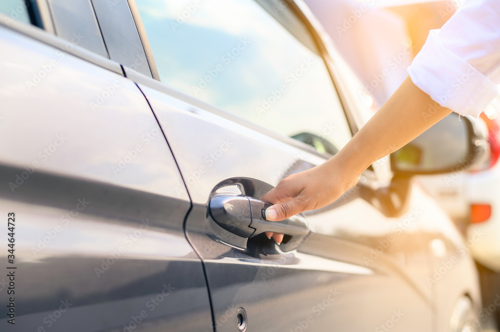 A focus image of a businesswoman's hand opening the car door