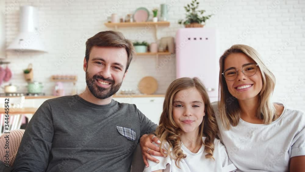 Portrait of happy caucasian family sitting on sofa with cups of tea and watching TV at home. Father switching channels, slow motion Portrait of happy caucasian family sitting on sofa with cups of tea and watching TV at home. Father switching channels, slow motion