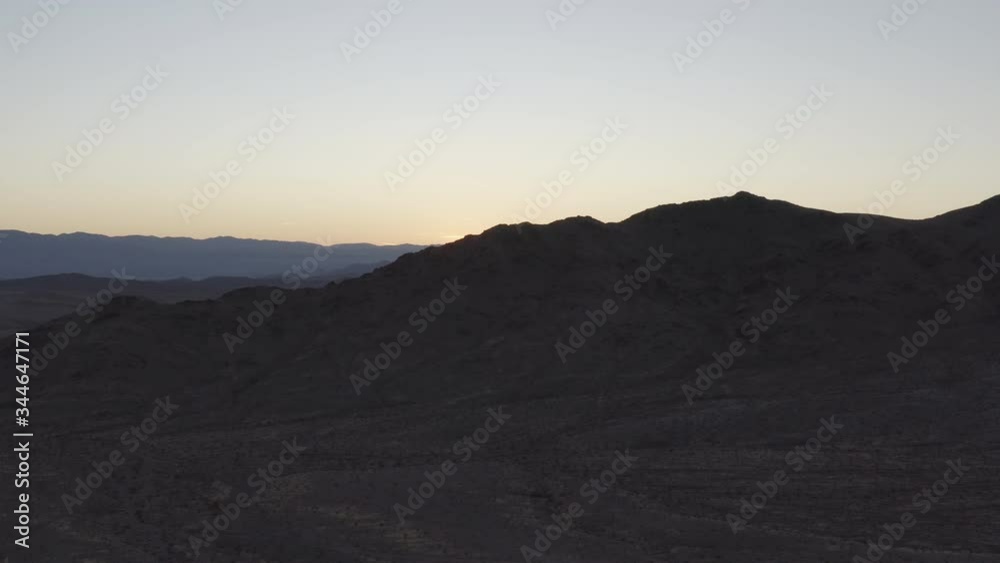 An aerial tracking shot of the Avawatz Mountains at dusk as seen from the South Nopah Range in Tecopa, Ca. Drone take off, landing and operation conducted outside of wilderness boundary.