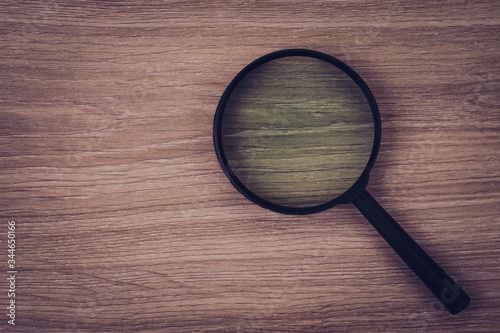 magnifying glass on wooden background