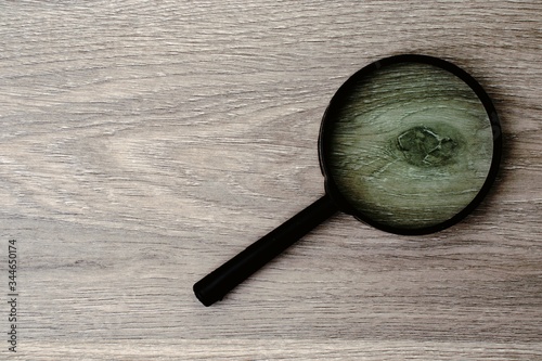 magnifying glass on wooden background