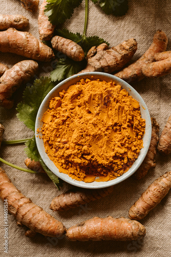 Turmeric roots and powder as background. Organic and healthy food. Close up view. 	