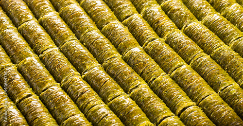 Traditional turkish baklava with roll-shaped pistachio. Sweet, bright background, banner.