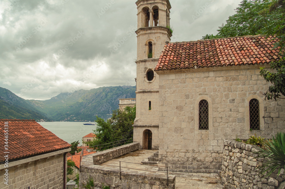 Cloudy day in the old town on the Bay of Kotor. Bell tower of St Nicholas church. Nature and travel. Montenegro, Perast Cloudy day in the old town on the Bay of Kotor. Bell tower of St Nicholas church. Nature and travel. Montenegro, Perast