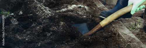 farmer digs a hole by shovel in garden