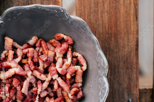 Lardons fumés en lamelles dans un bol sur la table de la cuisine
