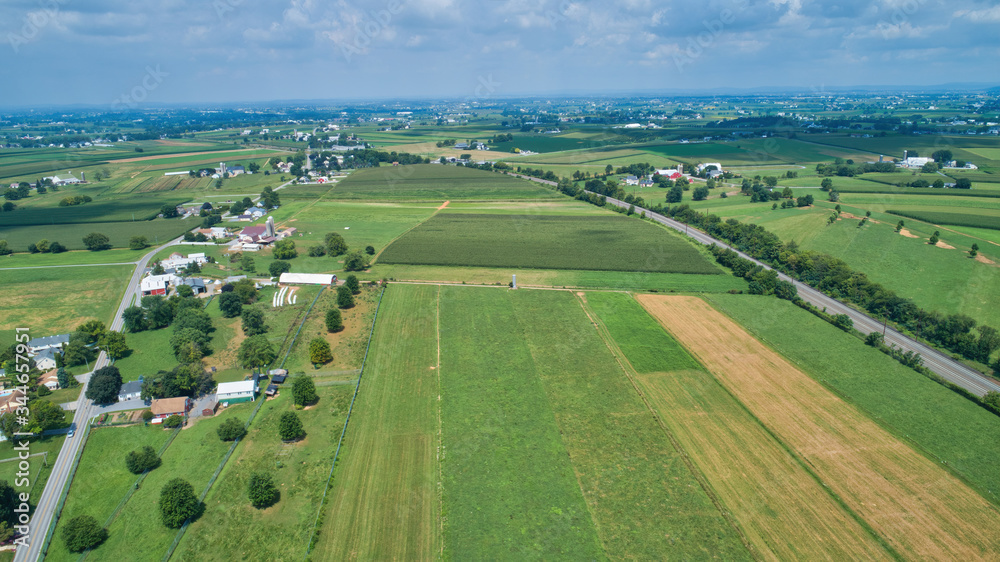 Aerial view of farm lands in summer with blue skies and white fluffy clouds
