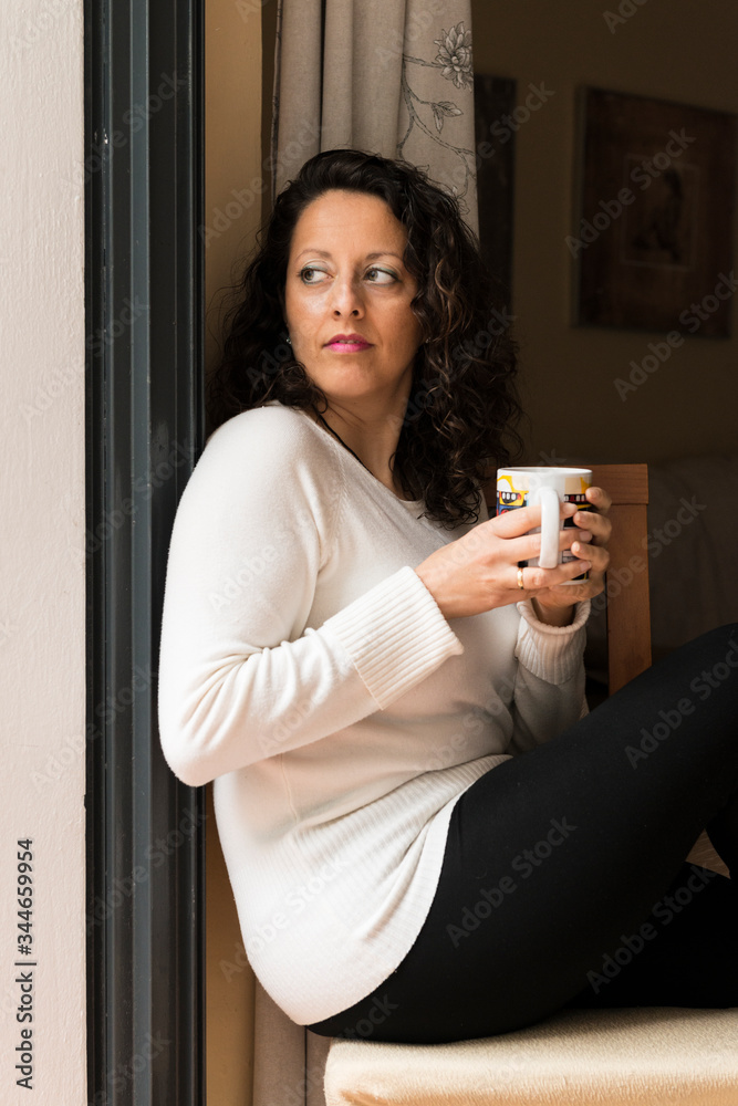 A woman with a cup in her hands. A woman with a cup in her hands.