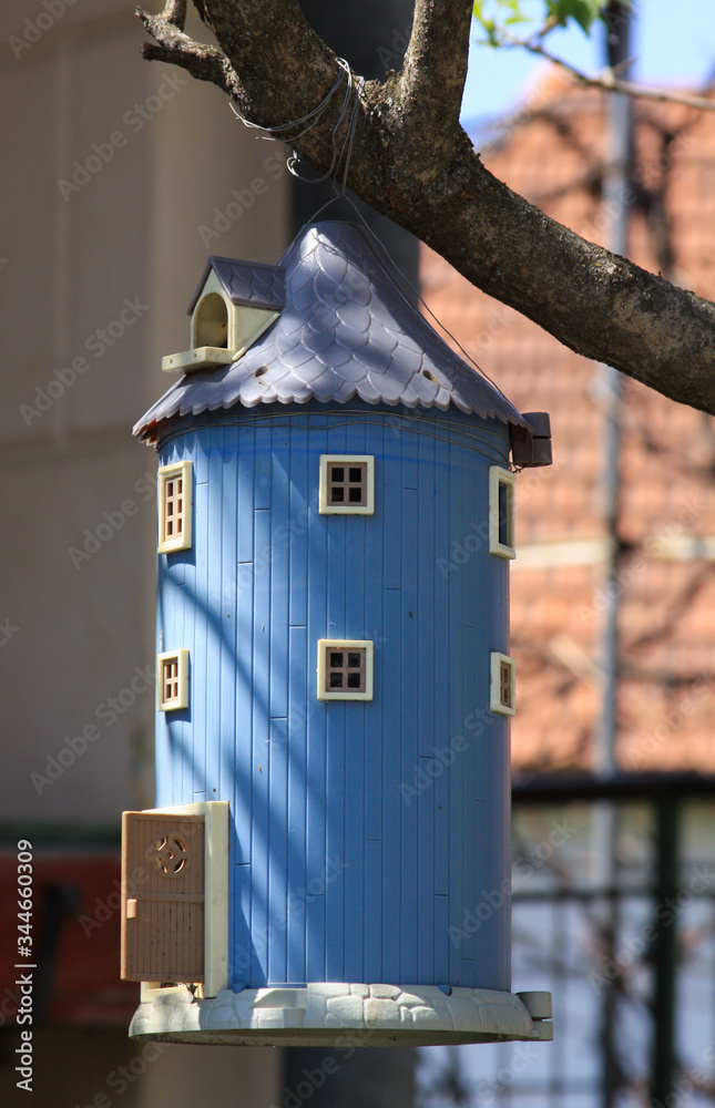 Blue birdhouse shaped like a miniature barn Blue birdhouse shaped like a miniature barn