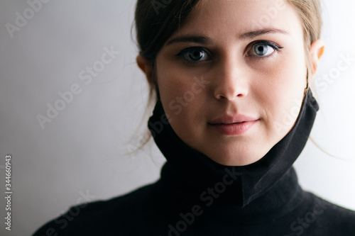 Фотография face portrait of a young woman with a black mask under her chin, girl took off t