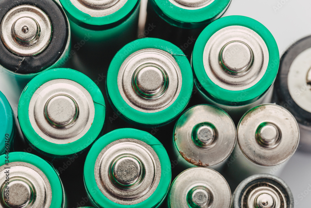 many new and used alkaline the positive ends of battery cells. type AA on a light background. many new and used alkaline the positive ends of battery cells. type AA on a light background.