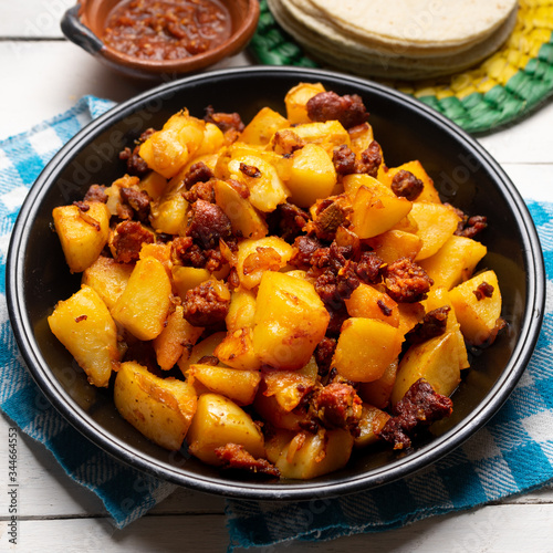 Mexican potatoes with chorizo on white background