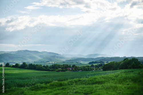 Rural landscape somewhere in Europe. Countryside farm, trees, green field, sunlight and cloud